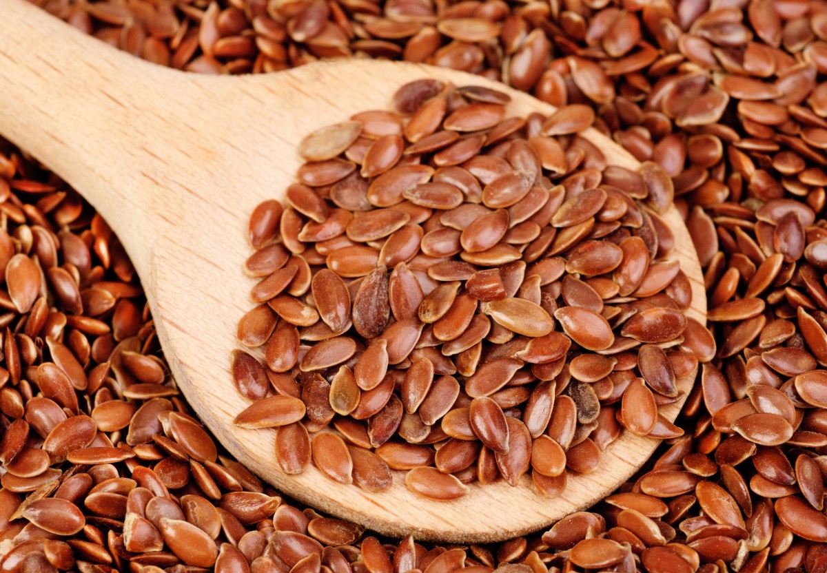 close up of flax seeds and  wooden spoon food background