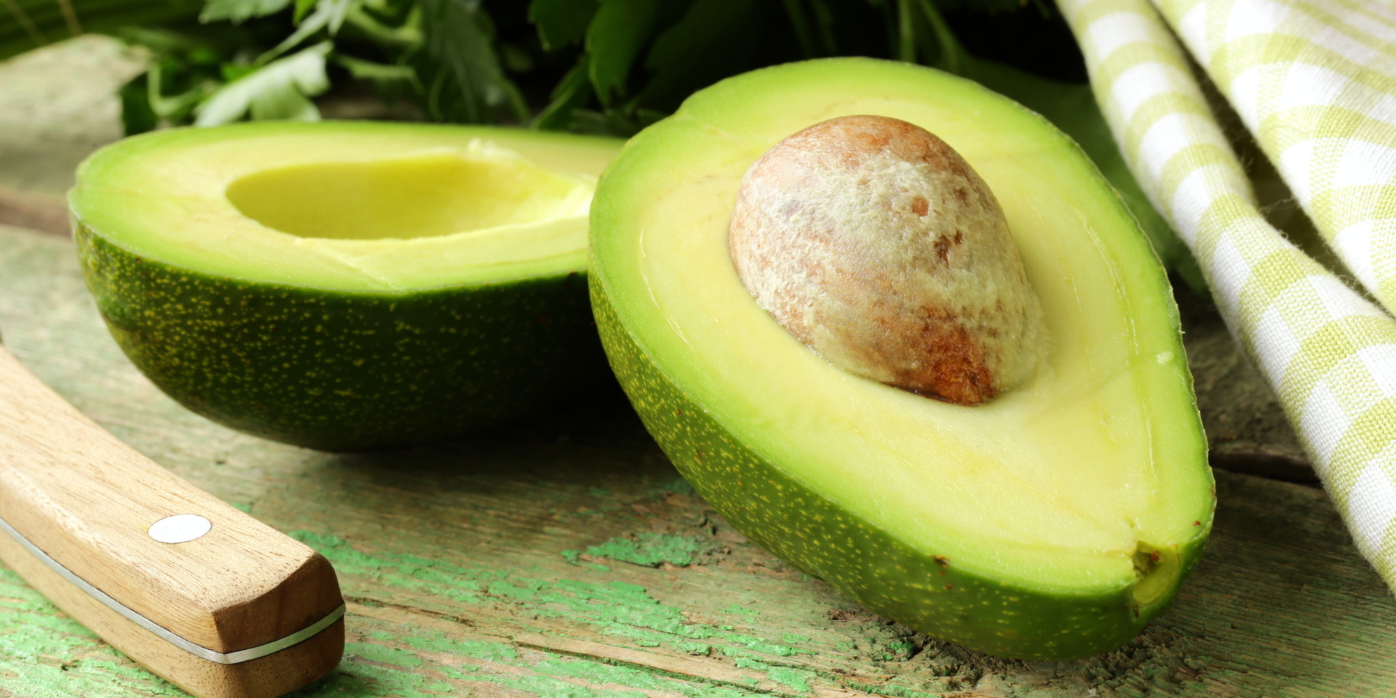 ripe avocado cut in half on a wooden table