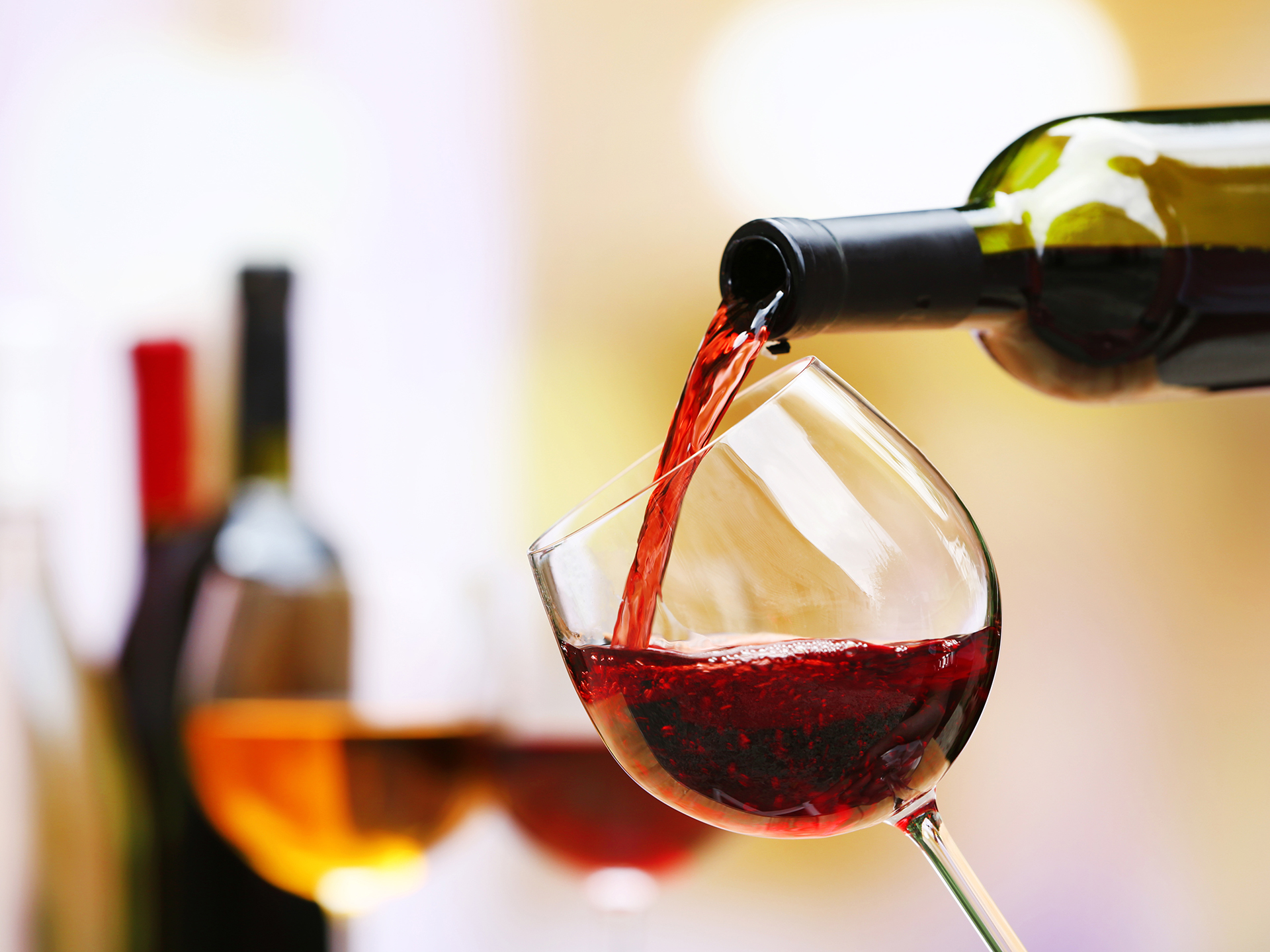 Red wine pouring into wine glass, close-up