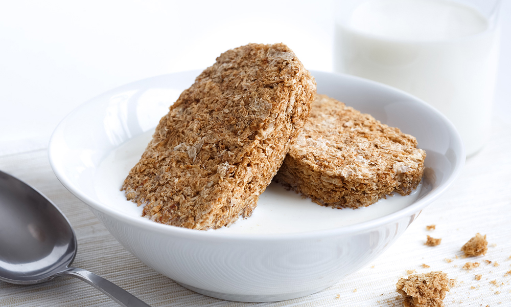 White bowl with two whole wheat breakfast biscuits isolated on white with milk, bottle and spoon. Crumbs on placemat.; Shutterstock ID 368261606